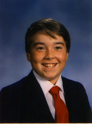 School portrait of Scott Thomas Palmer, smiling, wearing a navy blazer and red tie.